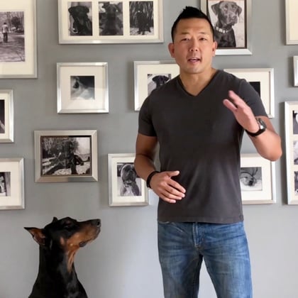 Photo of a Man, Michael Shikashio, next to his Doberman